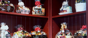 Several burgundy shelves filled with assorted gift baskets wrapped in cellophane.